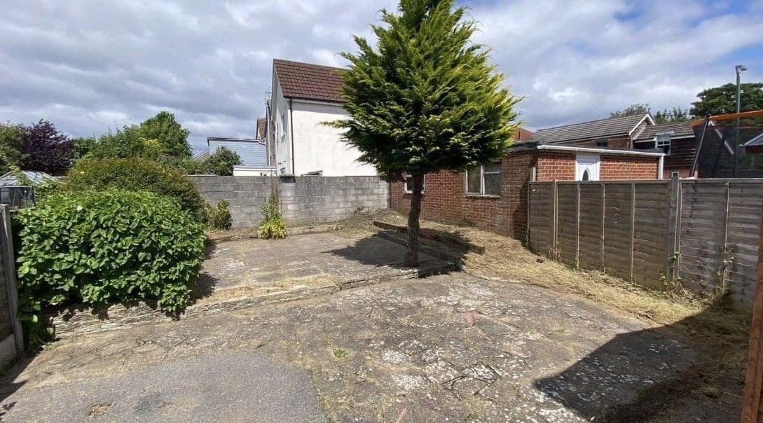 Rear garden cleared of weeds and long grass, leaving a clean patio area