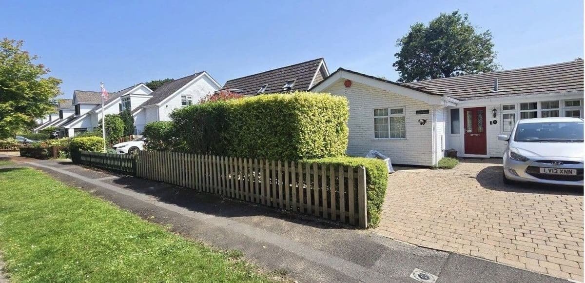 Neatly shaped hedge in front of a white bungalow in Sway